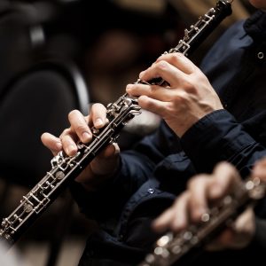 Hands of a musician playing the oboe in an orchestra